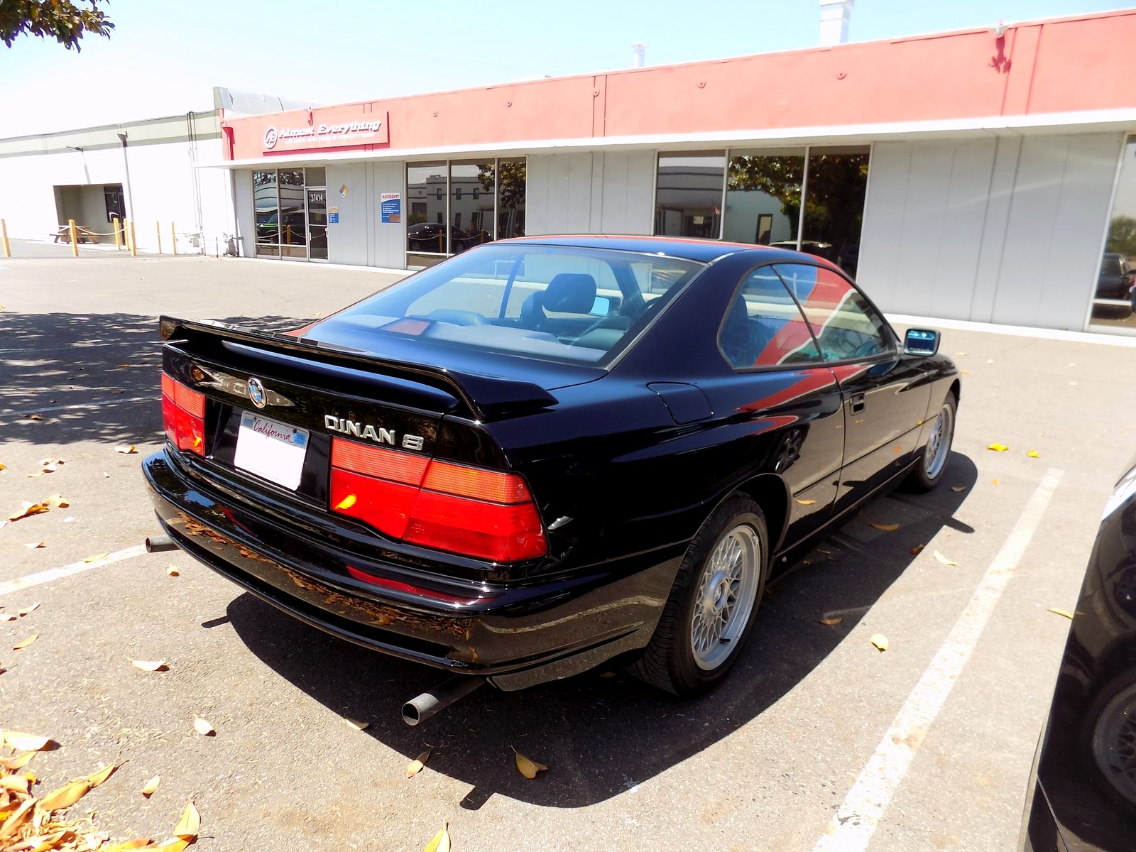 Almost Everything Auto Body storefront at 37414 Centralmont Place with a freshly painted black 1992 BMW 850i